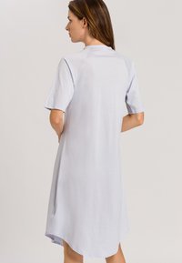 Abito azzurro chiaro a maniche corte con una vestibilità comoda, orlo arrotondato e tessuto liscio. Design semplice senza modelli o accenti visibili.