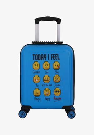 Kovale v trdi lupini v modri barvi z emoji obrazki, ki predstavljajo čustva. Ima zložljivo ročico in štiri večsmerne kolesa.