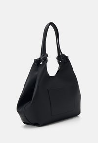 Black leather tote bag with textured surface, dual knotted handles, and a front pocket. Smooth, structured design with a spacious opening.