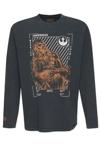Langærmet, mørkegrå t-shirt med et brunt Chewbacca grafisk design, der inkluderer tekst og grafiske elementer, som beskriver hans art og egenskaber.