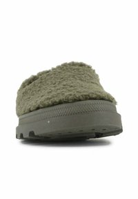 Zaļas vilnas slip-on kurpes ar teksturētu augšdaļu un biezu gumijas zoli, kurai ir notekcaurules un modelēts sānu akcenta dizains.