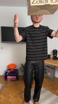Striped t-shirt with green and red lines, paired with black faux leather pants. Individual holds a cardboard box labeled "Zalando."