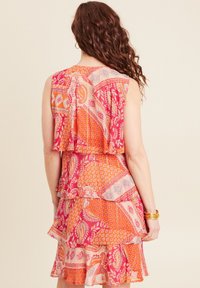 Mehrfarbiges Kleid mit geschichteten Rüschen und Paisley- sowie geometrischen Mustern in Rosa, Orange und Creme. Ärmelloses Design mit enganliegendem Oberteil.