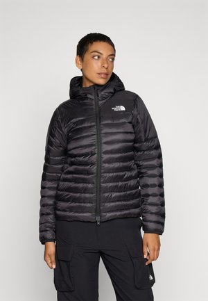 Svarte isolerte jakke med hette, med en kviltet design, front glidelås og logo på brystet. Glatt, shiny overflate.
