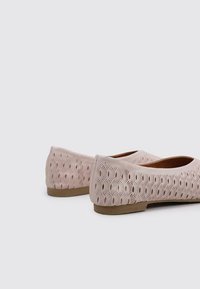 Bailarinas rosas con un patrón de hojas perforadas, punta redonda y tacón bajo. Los materiales parecen ligeros y flexibles con una textura suave.