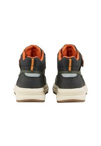 Baskets de sport gris et orange avec un col rembourré, une sangle Velcro et une semelle en caoutchouc texturée. Présente des accents orange contrastés.