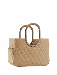 Quilted beige tote bag with two rounded handles, featuring a contrasting circular hardware detail and side pocket. Smooth, textured surface.
