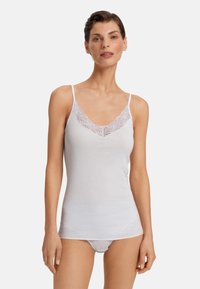 Bílá tílko s tenkými ramínky, s průhledným krajkovým výstřihem do V a měkkou, hladkou texturou. Jednoduchý a přiléhavý design.