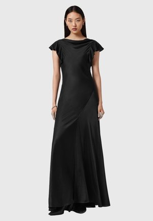 Czarna satynowa sukienka z dekoltem w łódkę, krótkimi falbaniastymi rękawami i dopasowaną sylwetką. Posiada skośne szwy i zwiewną spódnicę.