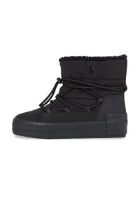 Botas de tobillo negras con suela de goma, parte superior acolchada, cordones elásticos y un borde de pelaje sintético en el cuello. Logo de Calvin Klein en relieve en el lateral.