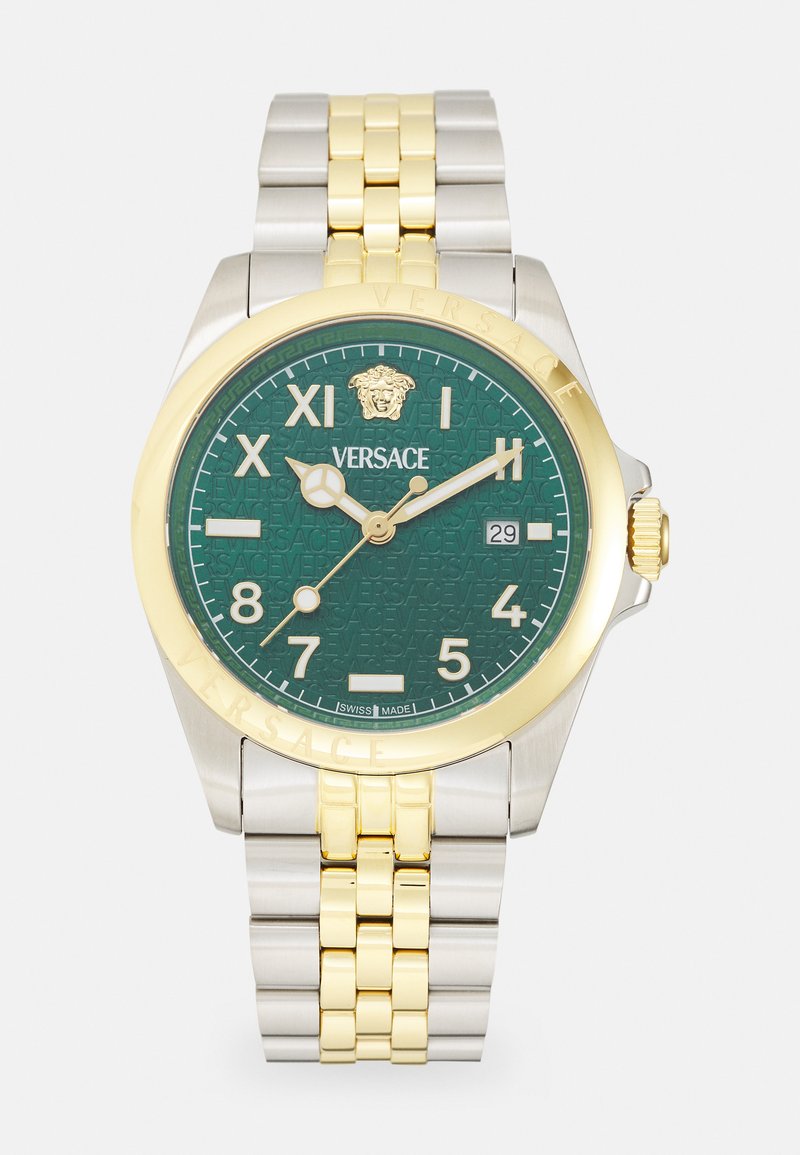 Montre Versace avec un cadran texturé vert, des index horaires rehaussés d'or, un bracelet en acier et or, et une lunette dorée. Indicateur de date à 3 heures.