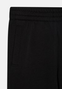 Nike Sportswear CLUB UNISEX - Tepláky - black/metallic gold