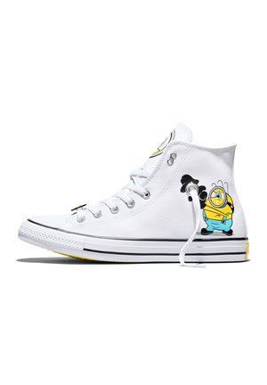 Witte hoge sneaker met een cartoon Minion-personage in blauwe overalls die een camera vasthoudt aan de zijkant bij de hiel.