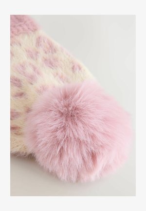 Pehmeä vaaleanpunainen neulottu kangas, jossa on herkkä pitsikuvio ja suuri, pörröinen pom-pom kiinnitetty reunoihin.