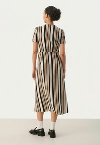 Raitapaita midi-mekko lyhyillä hihoilla, joka esittelee pystysuoria raitoja mustassa, kermanvärisessä, ruosteenpunaisessa ja ruskeassa värissä. Sujuva kangas ja räätälöity istuvuus.