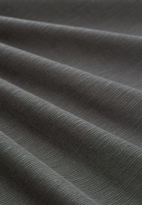 Țesătură texturată de culoare gri închis, cu o țesătură diagonală subtilă, care evidențiază pliuri delicate și o suprafață netedă și uniformă.
