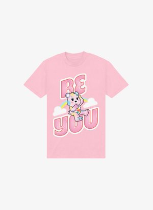 Camiseta de algodón de color rosa claro con un oso de dibujos animados, un arcoíris y el texto "SÉ TÚ MISMO" en tipografía audaz y divertida.
