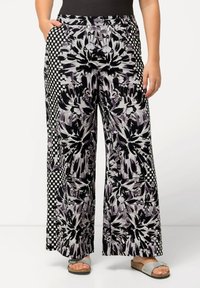 Brede broek met een bloemenpatroon in zwart, grijs en wit, met een geruite detail aan de zijkanten. Elastische tailleband voor comfort.