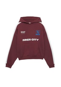 Vinrød hættetrøje med frontlomme, hvide sidelommer og trykt tekst, inklusive "INNER CITY" og en blå logo. Blødt, afslappet design.