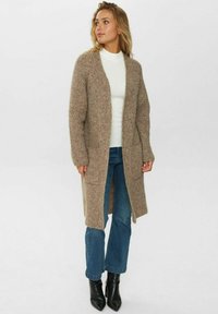 Virkat, öppet fram cardigan i ljusbrunt med ribbad textur. Har långa ärmar, sidofickor och slutar strax under höfterna.