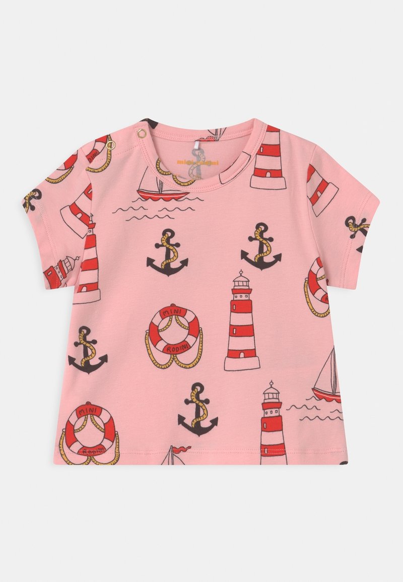 Różowy t-shirt dla małych dzieci z czerwono-białą latarnią morską, czarnym kotwicą z liną, czerwono-białą bojką ratunkową oraz wzorami małych żaglówek.