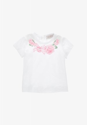 T-shirt bianco in cotone con stampa floreale di rose rosa e un nastro a righe rosa sul petto. Maniche corte e chiusura a occhiello sul retro.
