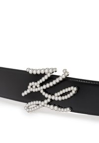 Čierny kožený opasok s dekoračným strieborným kovovým dizajnom zdobeným bielymi perlami usporiadanými vo vlnkovanom vzore.