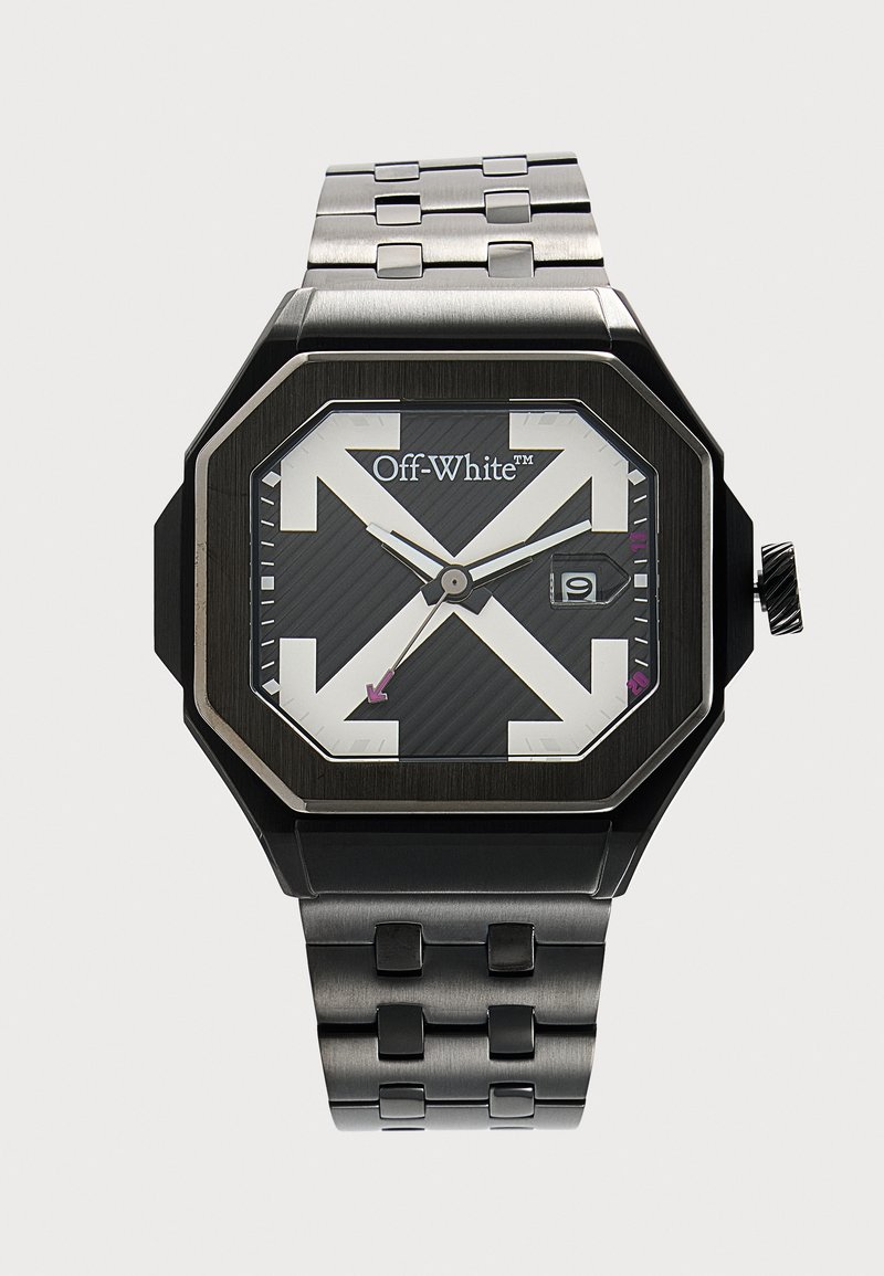 Montre carrée noire et argent avec grandes flèches blanches sur le cadran, logo Off-White, guichet de date et bracelet en maillons métalliques.