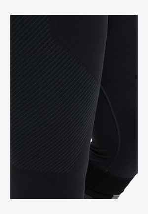 Black athletic leggings featuring textured fabric with horizontal stripes, a snug fit, and a seamless waistband design.