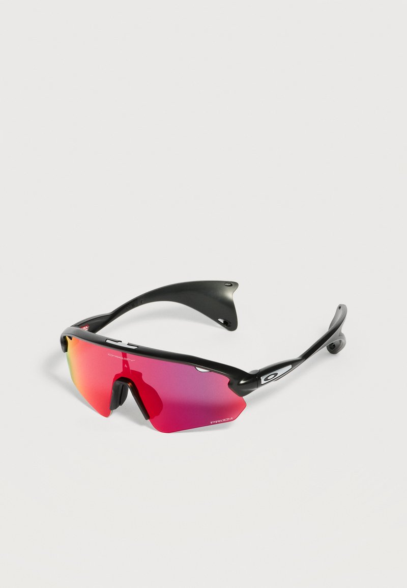 Αθλητικά γυαλιά ηλίου με μαύρο πλαίσιο, κόκκινα καθρεφτισμένα, περιμετρικά φακούς και μικρό λευκό λογότυπο Oakley στον βραχίονα, σε λευκό φόντο.