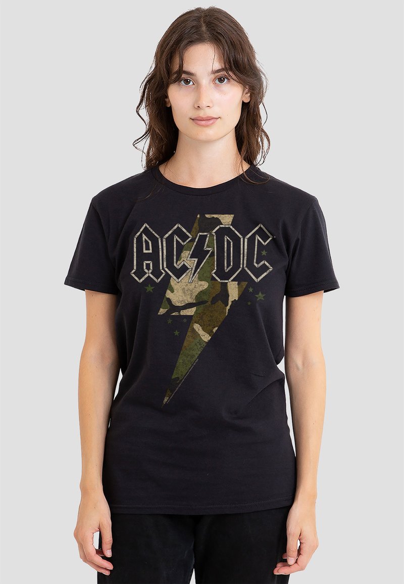 Schwarzes Baumwoll-T-Shirt mit einem großen Camouflage-Blitzgrafik und "AC/DC"-Text darüber, kurzen Ärmeln und klassischer Passform.