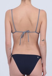 Ensemble bikini navy avec fines bretelles et design à nouer dans le dos. Matière texturée, bas de couleur unie, présentant un petit logo sur le côté.