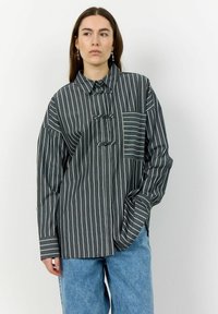 Striped button-up shirt in dark shades with a chest pocket. Features a unique collar and loose fit. Material appears soft with a textured finish.