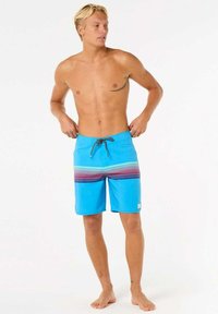 Pantaloni da bagno blu con un motivo a righe orizzontali in viola e verde. Realizzati in materiale leggero, con vita regolabile tramite cordoncino.