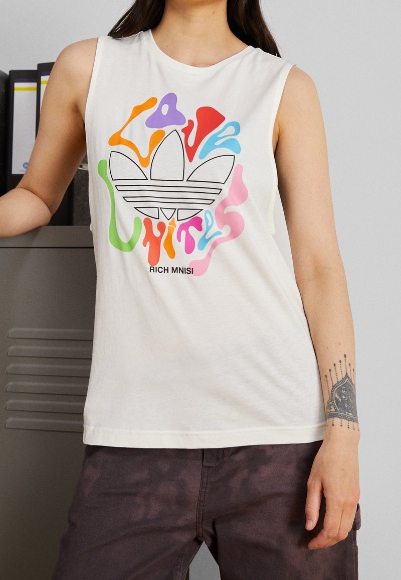 Witte katoenen T-shirt zonder mouwen met een kleurrijke grafische afbeelding met de woorden "Love Unites" en een Adidas-logo.