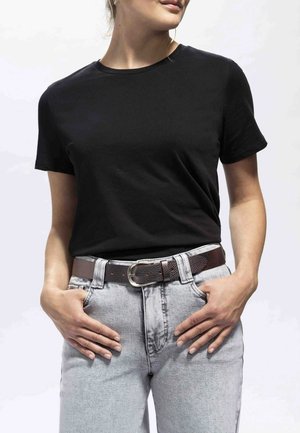 T-shirt noir à manches courtes avec un col rond associé à un jean taille haute gris clair et une ceinture en cuir brun texturé avec une boucle en argent.
