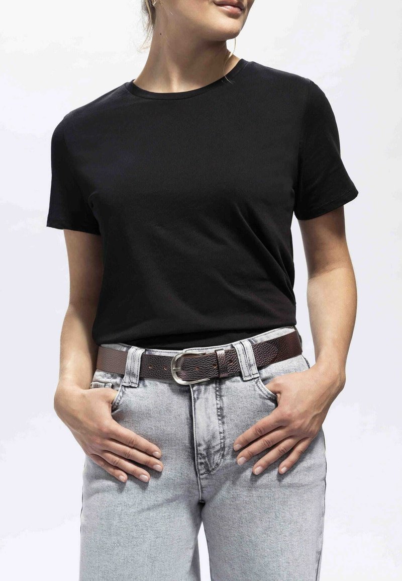 T-shirt noir à manches courtes avec un col rond associé à un jean taille haute gris clair et une ceinture en cuir brun texturé avec une boucle en argent.
