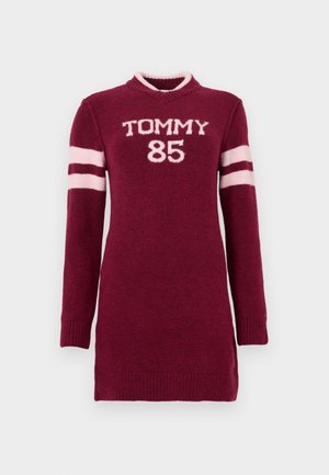 Bordeauxrotes Strickkleid mit langen Ärmeln, versehen mit weißem "TOMMY 85" Schriftzug und hellrosa Streifen an den Ärmeln. Gerippte Bündchen und Halsausschnitt.