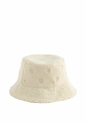 Smėlio spalvos medvilninis kibiro formos kepurė su siuvinėtomis gėlėtomis skylutėmis ir šiek tiek suplyšusiu kraštu, skirta kasdieniam dėvėjimui.