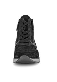 Zwarte sneaker met veters en zijritsen. Gemaakt van materiaal dat lijkt op leer met een getextureerde afwerking en een rubberen zool.