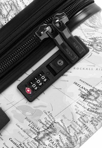 Cerniera nera su una valigia trasparente con un design di mappa del mondo. Include una serratura a combinazione nera con un piccolo emblema rosso.