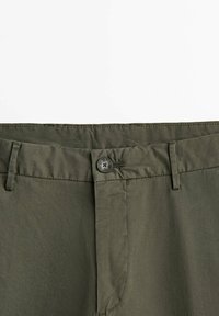 Pantaloni in cotone verde oliva con chiusura a bottone, passanti per cintura e una texture liscia. Il design presenta una vestibilità standard senza motivi visibili.