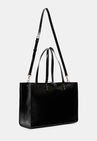 Borsa tote in pelle nera con finitura liscia, doppie maniglie, tracolla regolabile e dettagli hardware in tono oro.