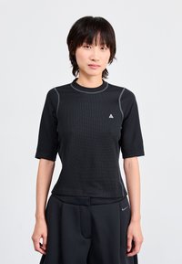 Black athletic short-sleeve top with a textured fabric, crew neckline, and grey accent stitching. Features a small logo on the chest.