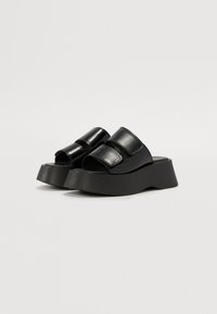 Black platform sandals with an open toe design, featuring two wide straps and a textured finish, mounted on a chunky heel.
