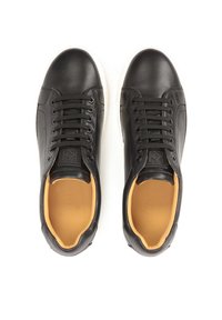 Zapatillas deportivas de cuero negro con un acabado suave, punta redondeada, diseño con cordones, suela blanca contrastante y forro interior color beige.