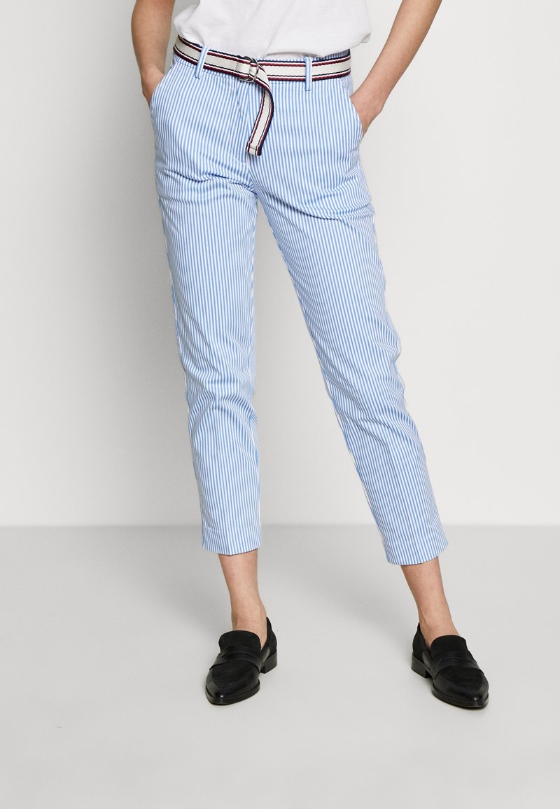 Blaue und weiße gestreifte Hosen mit taillierter Silhouette, die einen kontrastierenden Bund mit roten und marineblauen Akzenten sowie Seitentaschen aufweisen.