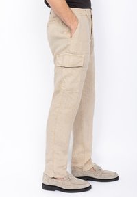 Beige linnen cargobroek met zijzakken en een relaxte pasvorm. Heeft een gladde textuur en een lichte glans. Combineer met lichte schoenen.