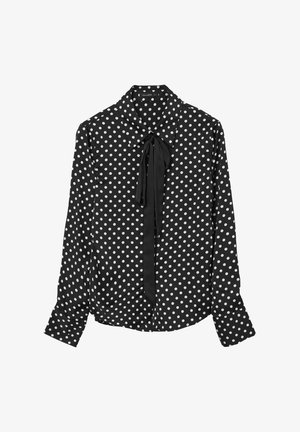 Blouse noire à pois avec des manches longues, un col et un détail à nouer au niveau du décolleté, fabriquée dans un tissu lisse et léger.