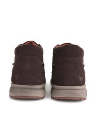 Stivaletti alla caviglia in suede marrone con suola in gomma beige, caratterizzati da cuciture minime e una finitura morbida e testurizzata per comfort e supporto.